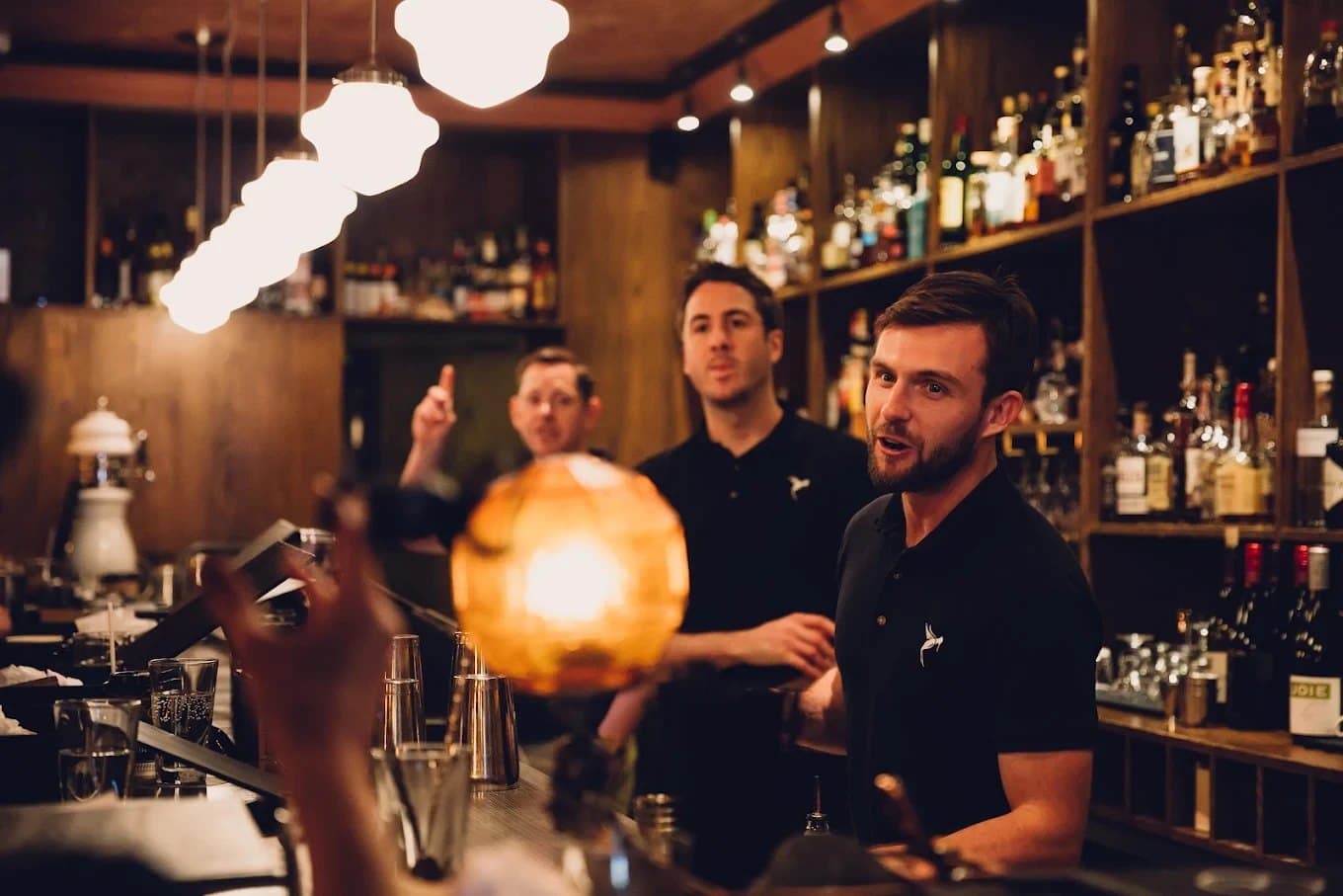Kyle Guilfoyle, founder of Guest Getter, talking with guests from behind a busy bar